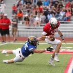 Blue player attempting to tackle a red player.