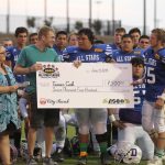 Players presenting Tanner Cook a check.